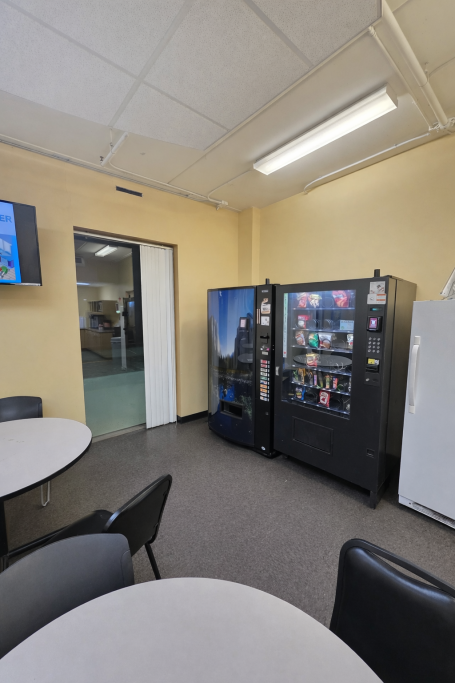 Break room with two vending machines and a table in a casual seating area.